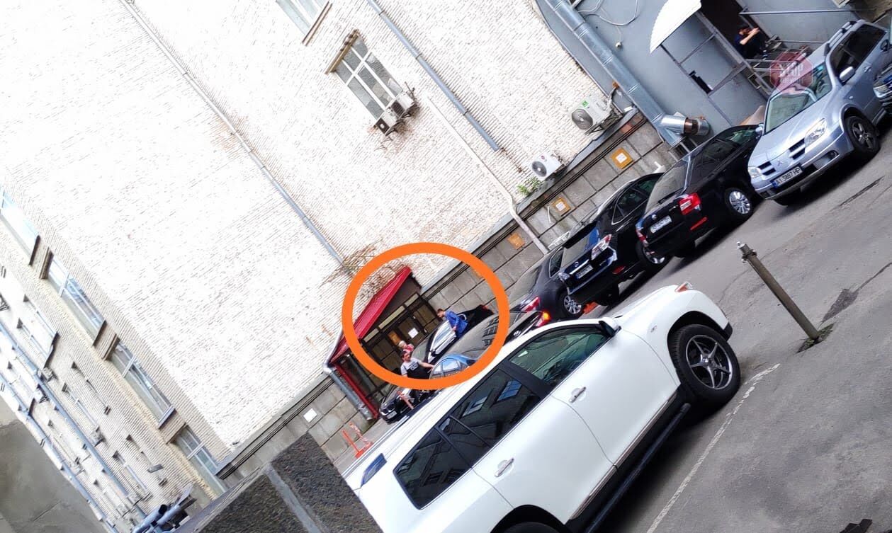 Пані Ольга сідає в автівку біля службового входу