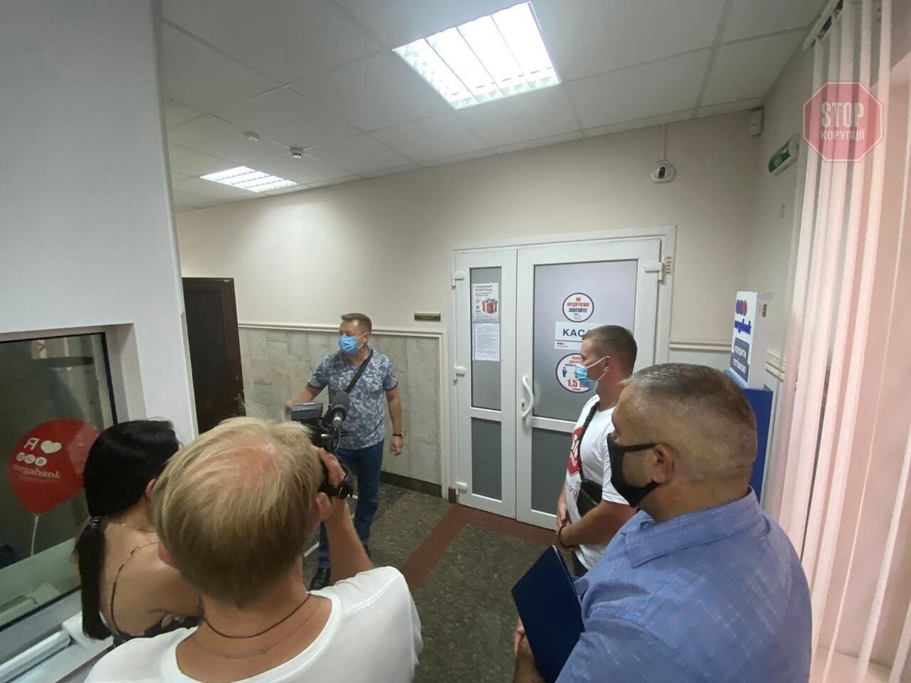  Правозахисники ГО «Стоп корупції» разом із поліцією спілкуються з представниками банку. Фото: СтопКор