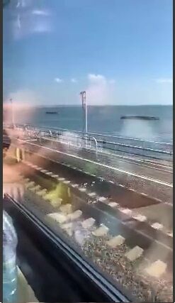 Над водой видны стоящие напротив опорных стоек моста бетонные сооружения.