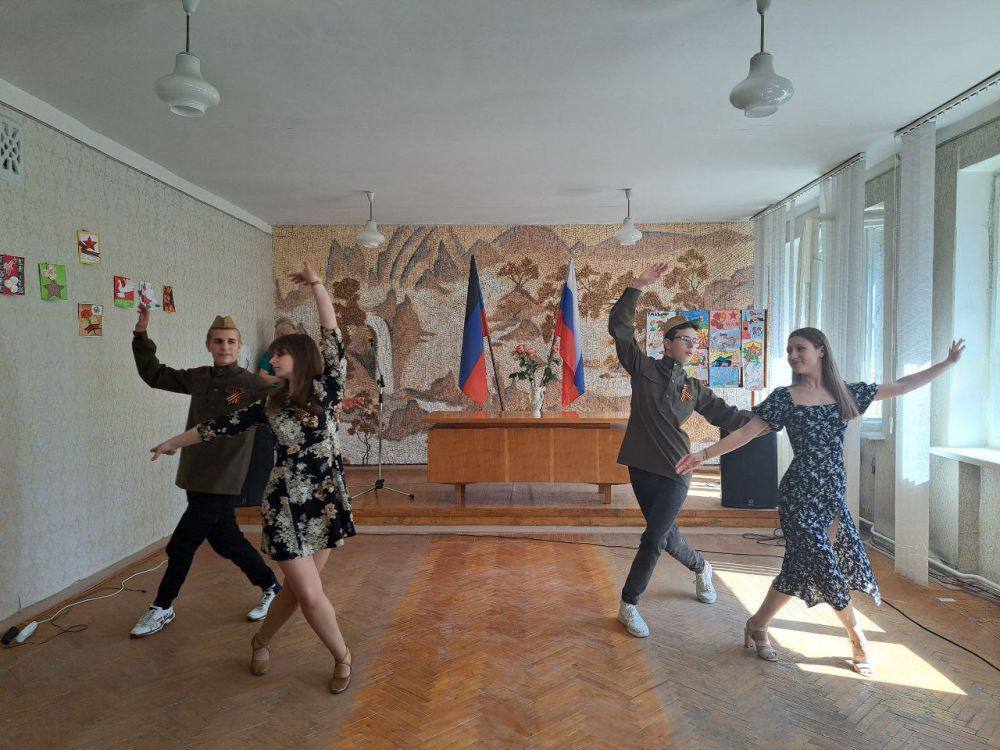 танцюють на фоні російського прапору