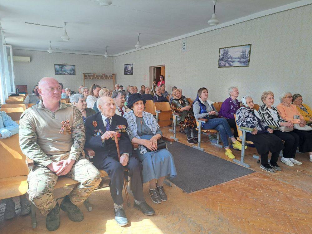 Пожилые люди сидят в зале