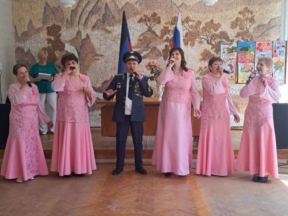 жінкии в рожевих сукнях співають