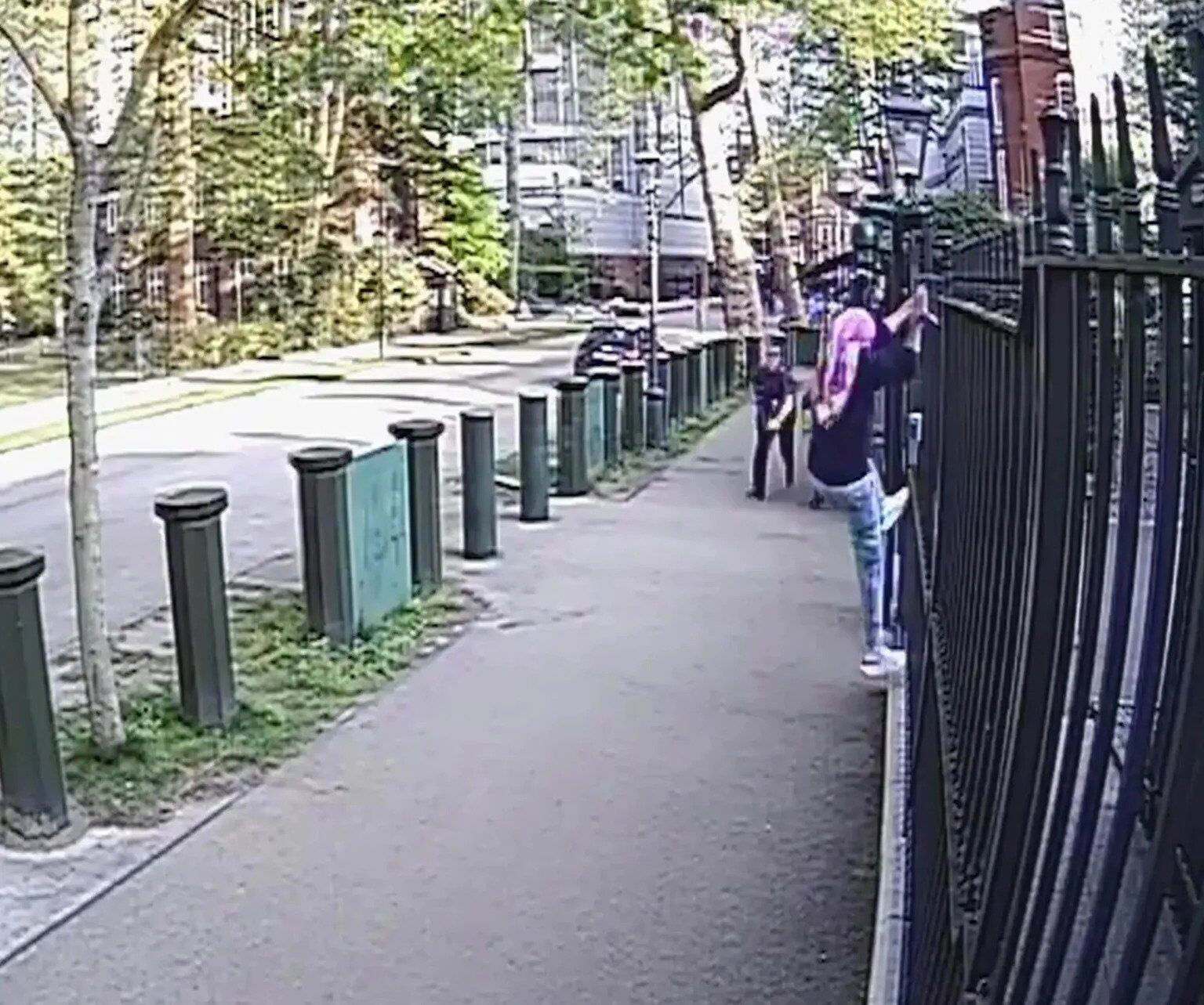 Мужчина в платке и очках подходит к изгороди израильского посольства в Лондоне.