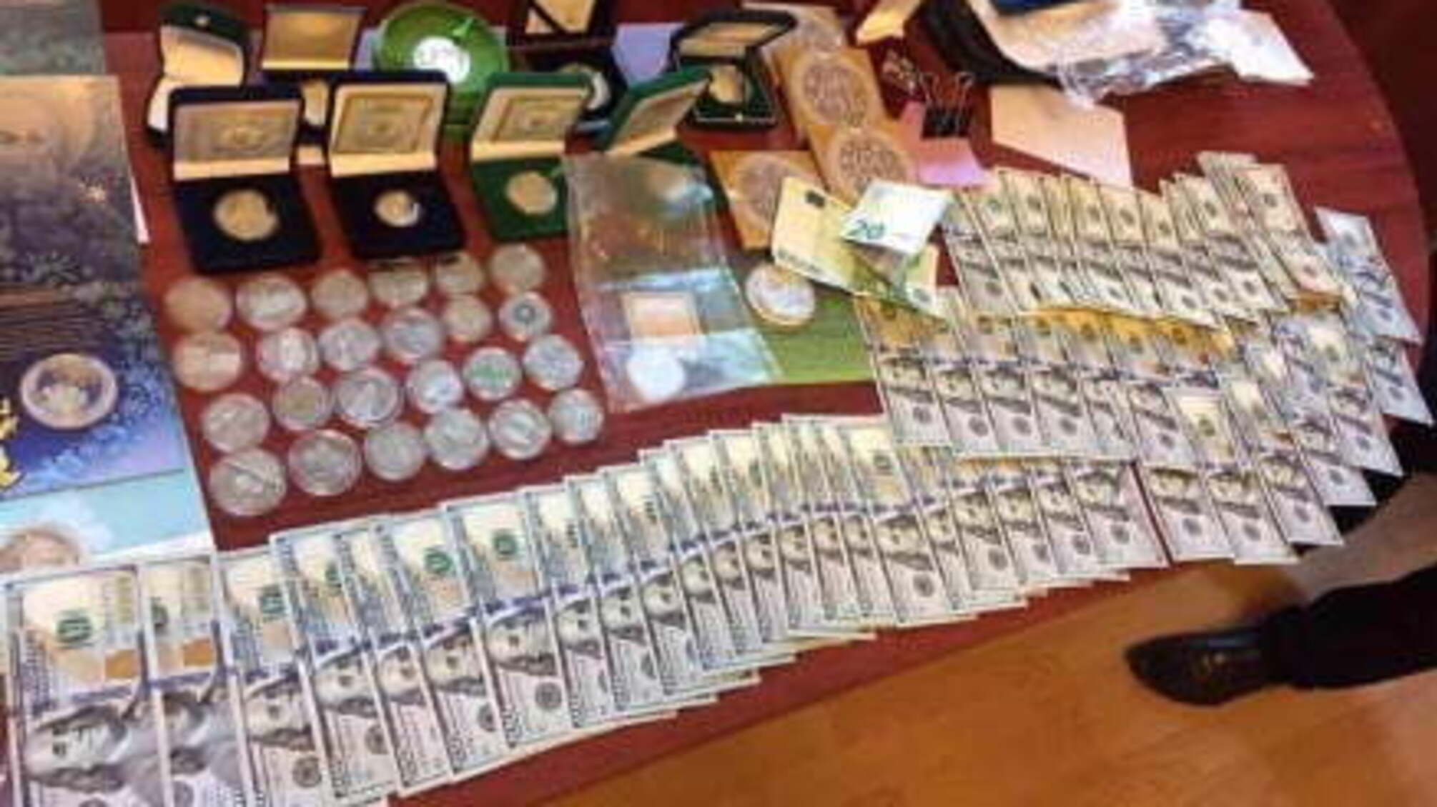 На Сумщині поліцейський зберігав вдома зброю та прапор РФ, а у кабінеті - золото і валюту