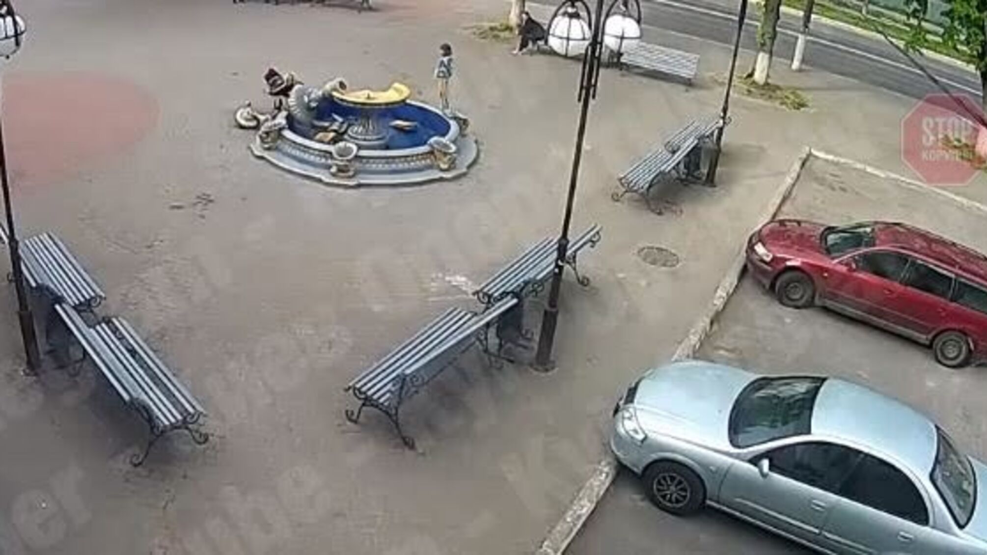 На Київщині неадекватна жінка з дитиною на плечах залізла на верхівку фонтана та розбила його (відео)