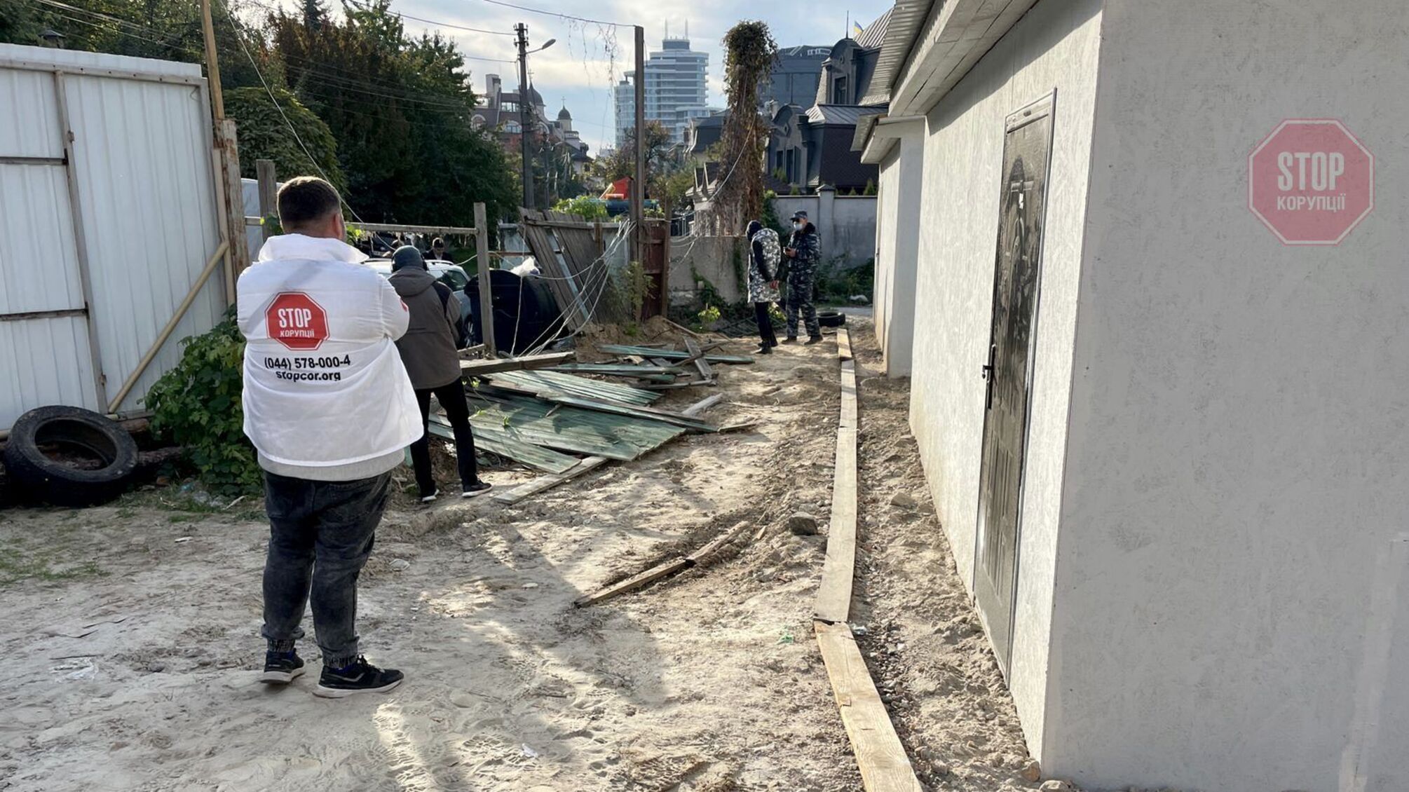 Не ринком єдиним: у центрі Києва комунальники взялися зносити паркан приватного будинку (фото)