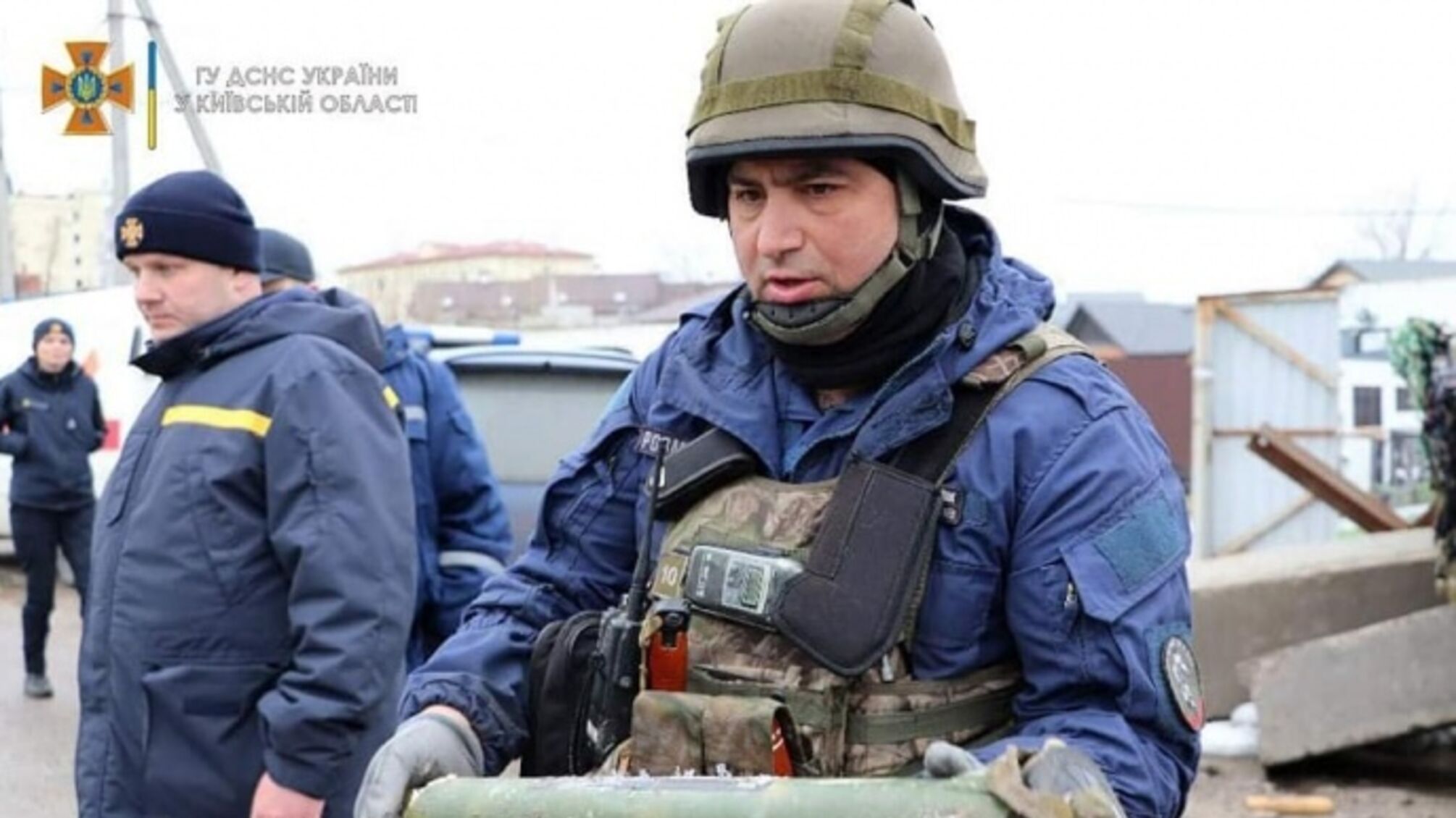 рятівник з вибухонебезпечним предметом в руках