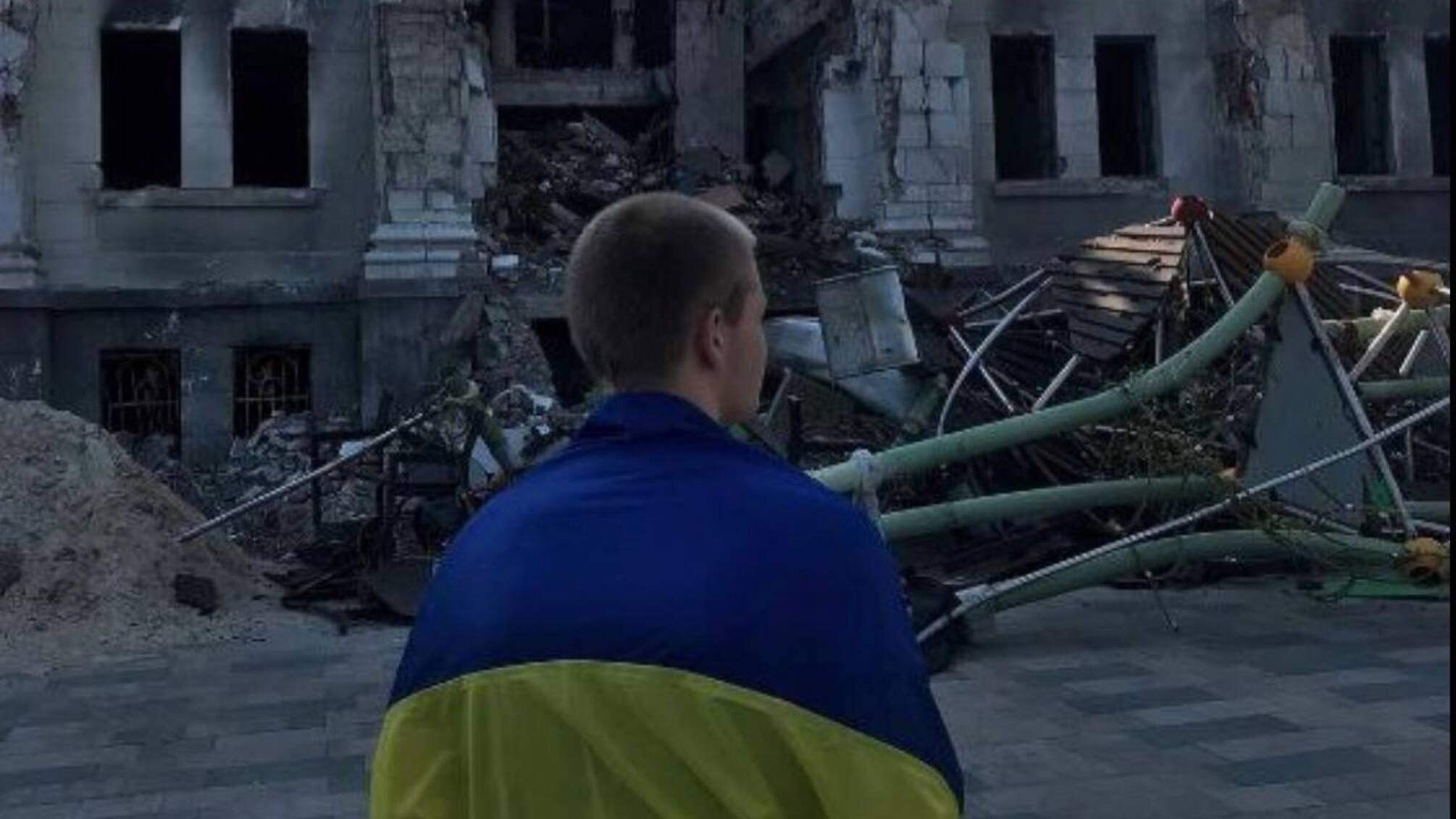 В оккупированном Мариуполе юноша вышел с флагом Украины к разбомбленному россиянами Драмтеатру (фото)
