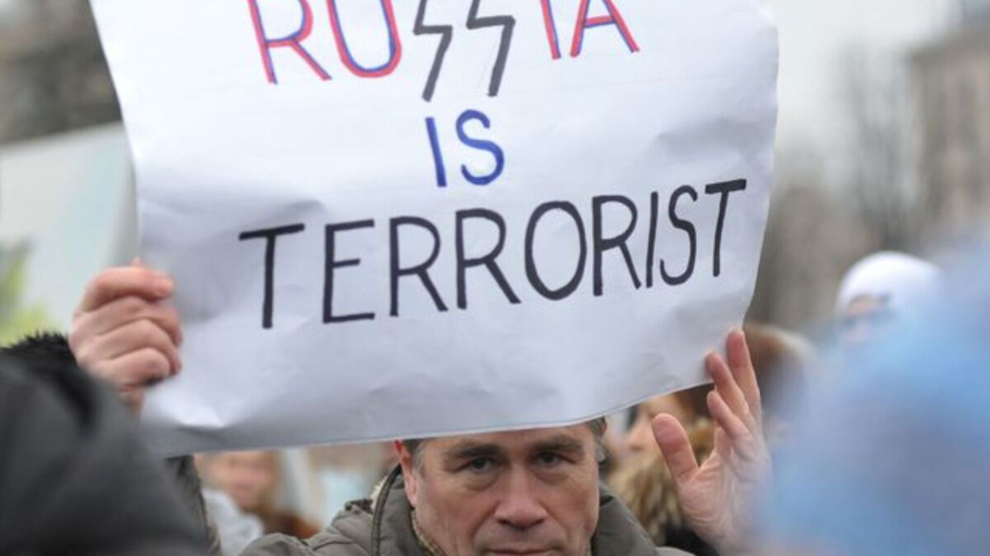 мужчина с плакатом russia is terrorist