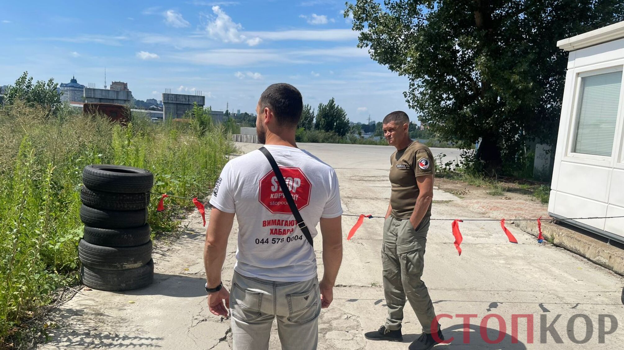 мужчина в футболке стоп коррупции и телохранитель