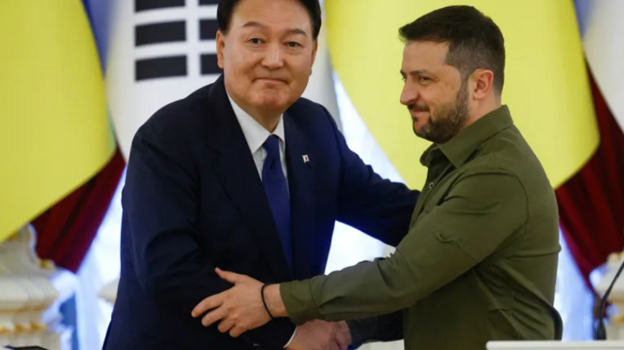 Президент Украины Владимир Зеленский и президент Южной Кореи Юн Сок Ёль пожимают друг другу руки после совместного заявления в Киеве