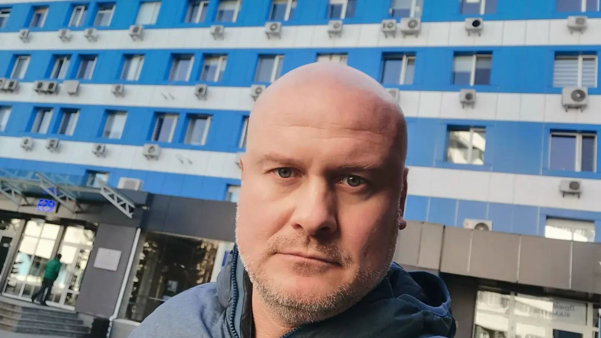 Вячеслав Узелков на фоне больницы