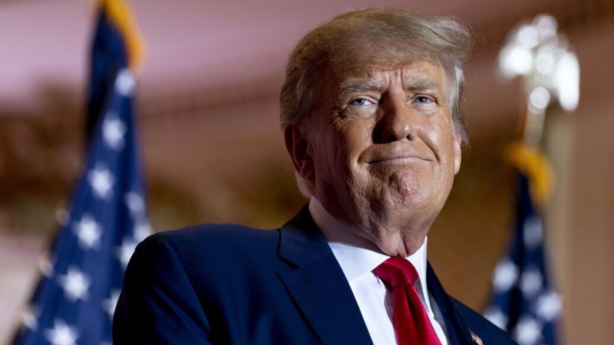 Дональд Трамп на фона прапорів