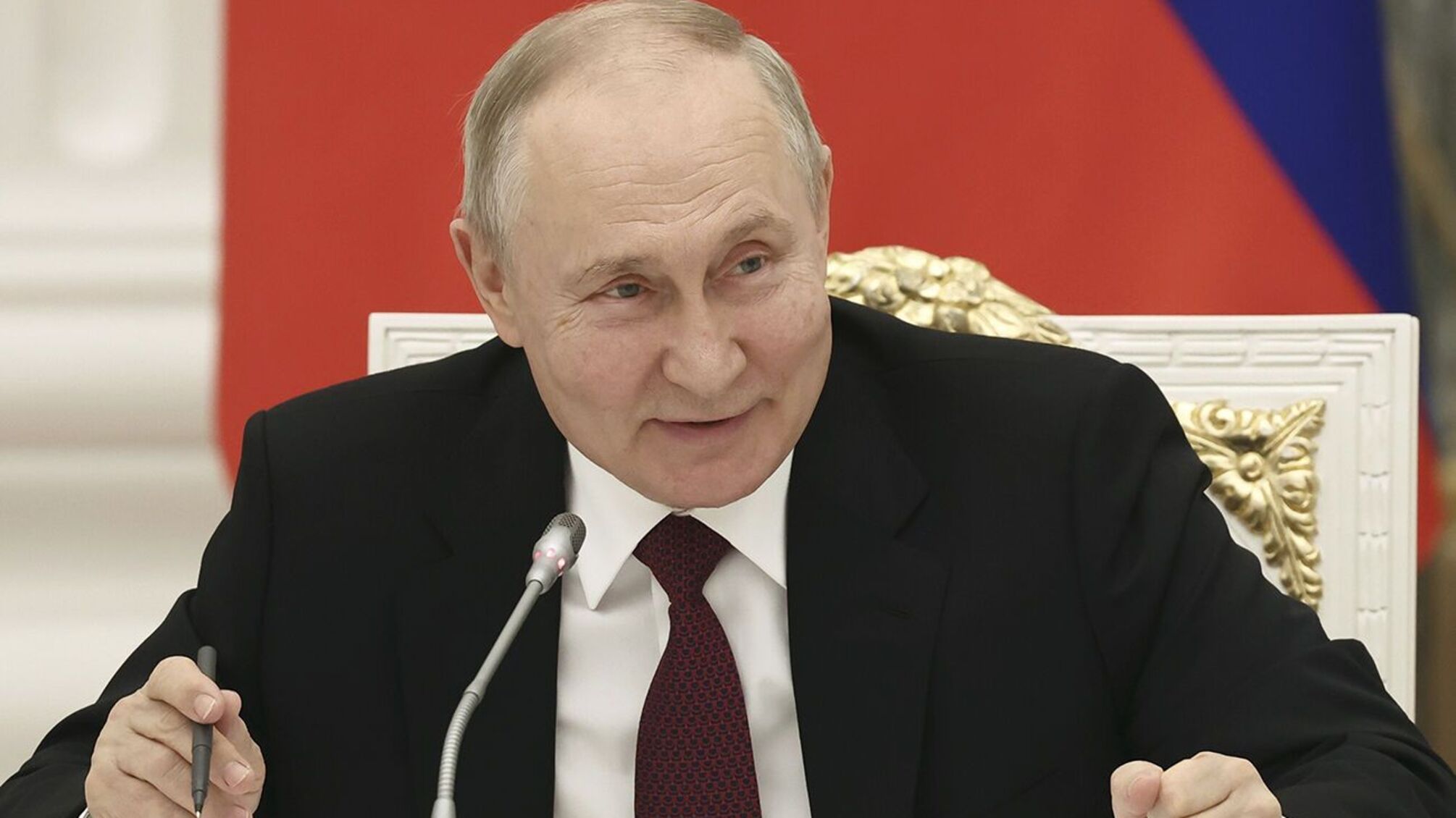 путин сидит на фоне флага россии