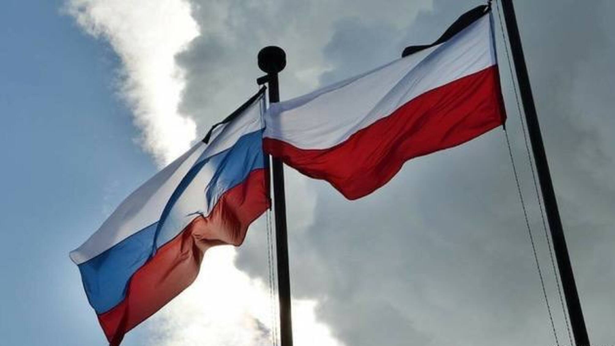 польський та російський прапори на тлі неба