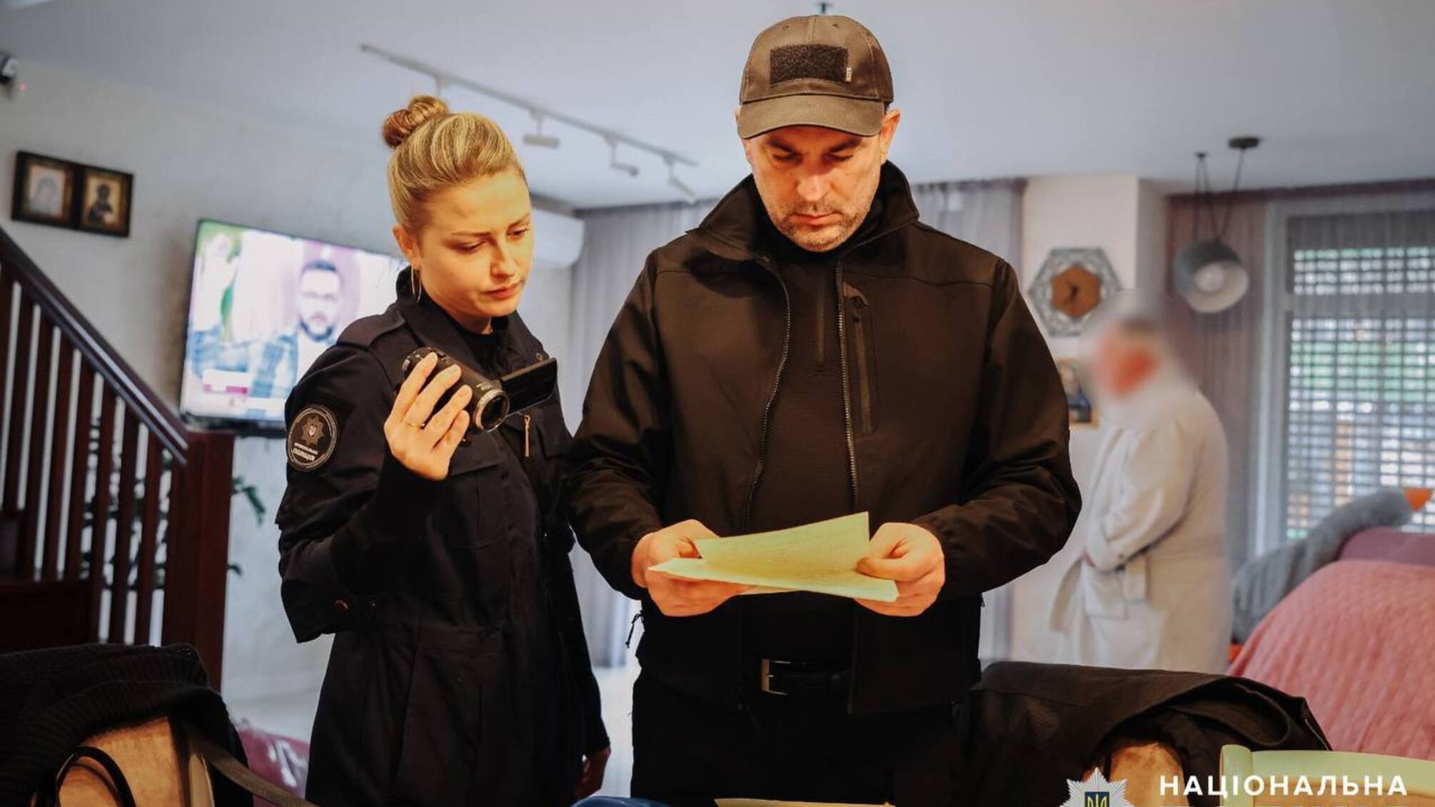 Жінка з камерою в руках та чоловік з паперами в руках