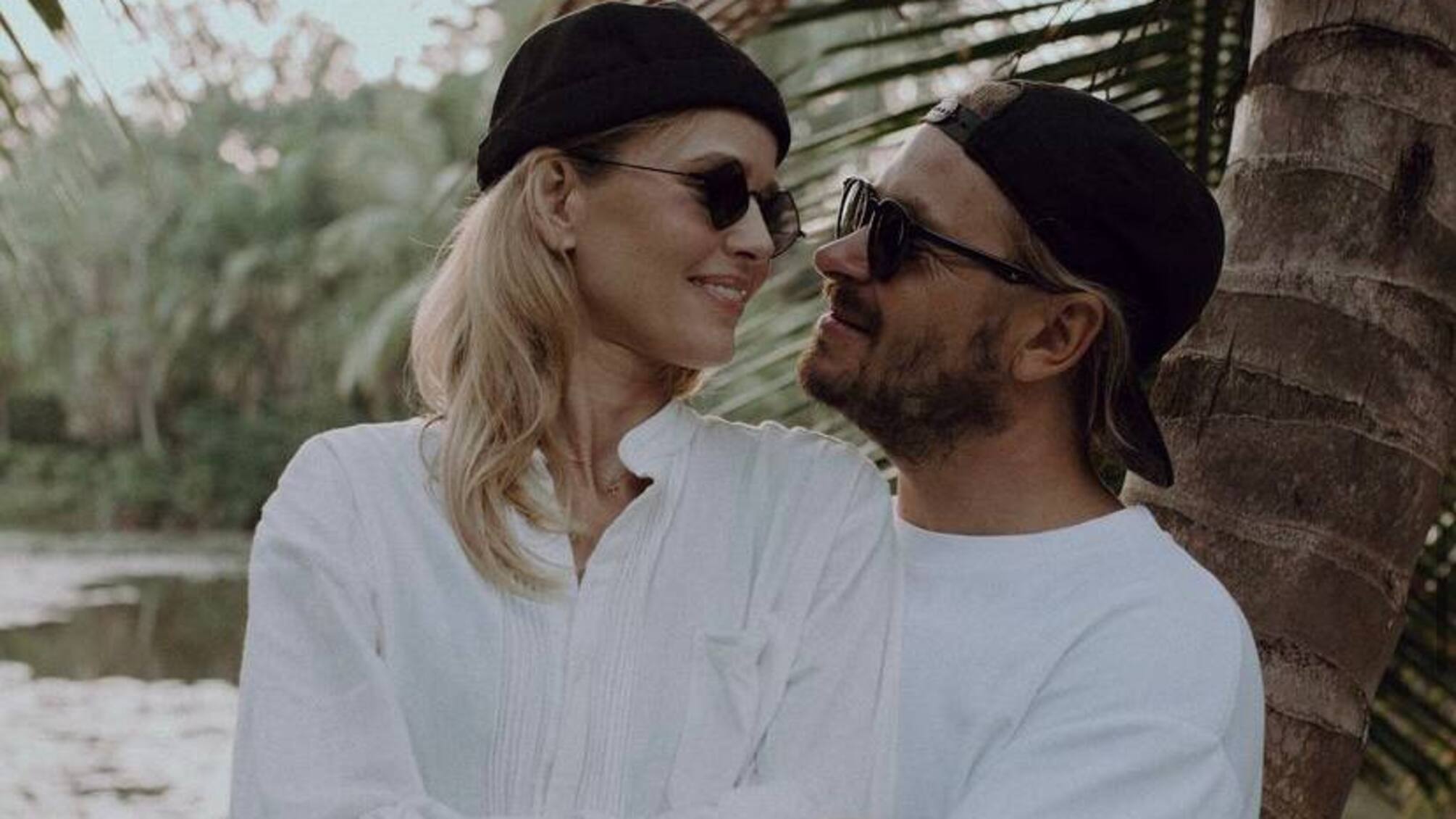 Мужчина и женщина обнимаются в белых рубашках.